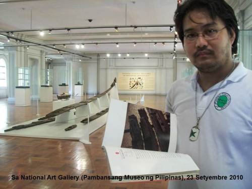 Xiao Chua, sa harap ng Butuan 1, ang pinakamatandang bangka na natagpuan sa Pilipinas, nang idisplay ito sa Pambansang Sinupan ng Sining. Kuha ni Camille Conde.