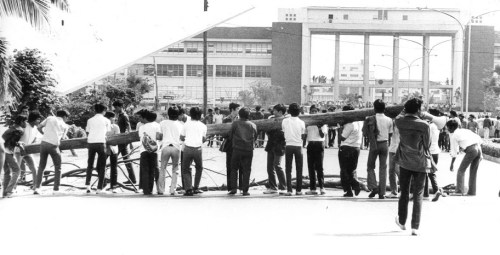 Pagbarikada sa University Avenue malapit sa Checkpoint (Gateway to the University ni Napoleon Abueva). Ngayon, sa gitna ng kalsada may marker para sa Diliman Commune. Mula kay Susan Quimpo.