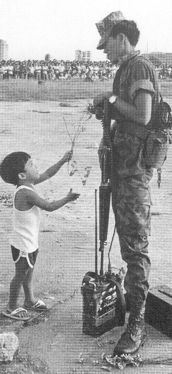 Ang batang nagbibigay ng bulaklak sa sundalo noong Himagsikang EDSA na nailagay sa likuran ng lumang limandaang piso. Mula sa People Power: An Eyewitness History.