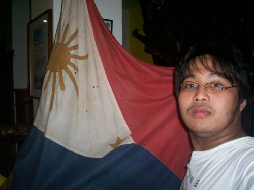 Si Xiao at ang isa sa mga bandilang Pilipino na ginamit noong himagsikan ni Heneral Martin Delgado.