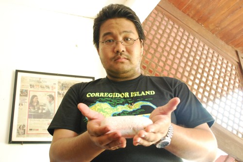 Si Xiao Chua habang hawak ang natural na namumulang "blood stone" sa Hotel Corregidor.  Kuha ni John Ray Ramos.