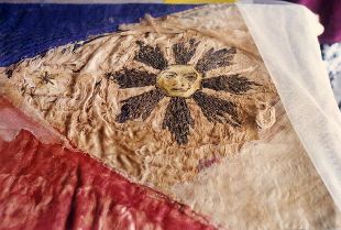 Ang araw sa delikado nang watawat na nasa pangangalaga ng mga Aguinaldo-Suntay sa Emilio Aguinaldo Museum sa Lungsod ng Baguio.  Mula sa watawat.net.