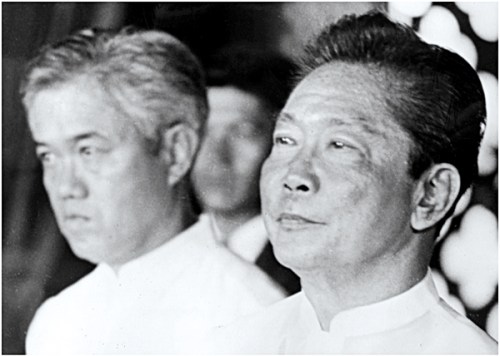 Si Primer Ministro Cesar Emilio Aguinaldo Virata sa likod ni Pangulong Ferdinand E. Marcos.  Mula sa Art Directors Trip Photo Library.