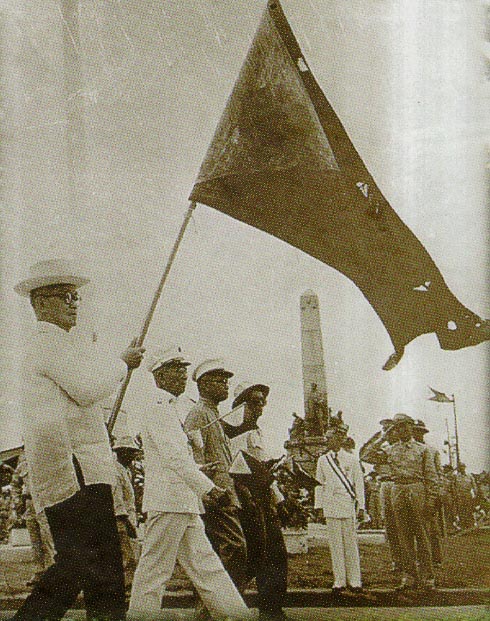 Si Henera Emilio Aguinaldo habang tangan-tangan ang bandilang Aguinaldo-Suntay sa harapan ng monumento ni Dr. Jose Rizal isang Araw ng Kasarinlan (July 4).