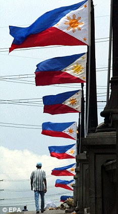 Mga watawat ng Pilipinas sa isang tulay sa Maynila.  Mula sa EPA.