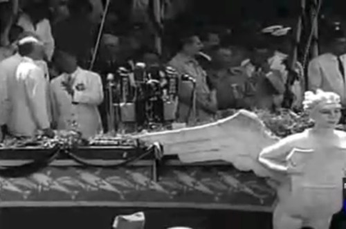 Ang pansamantalang grandstand sa hugis ng barko ng estado.  Mula sa newsreel na "Philippine Independence."