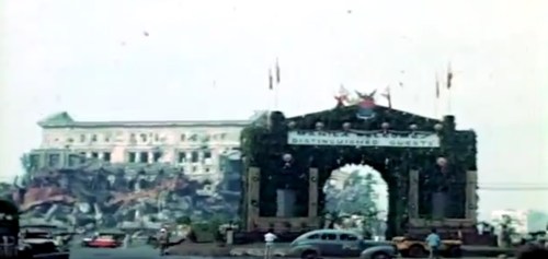 Ang nasirang Lumang Gusali ng kongreso at isang arko para sa pagdiriwang.  Mula sa newsreel ng FitchettFilm.com.