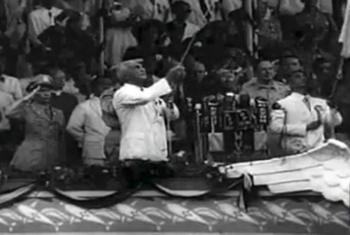 Si Paul V. McNutt habang ibinababa ang bandila ng Estados, at si Manuel A. Roxas habang itinataas ang bandila ng Pilipinas. Mula sa newsreel na "Philippine Independence."