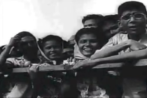 Ang bayan habang masayang sumasaksi sa kasaysayan.  Mula sa newsreel na "Philippine Independence."