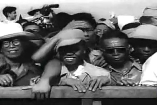 Ang bayan habang masayang sumasaksi sa kasaysayan.  Mula sa newsreel na "Philippine Independence."