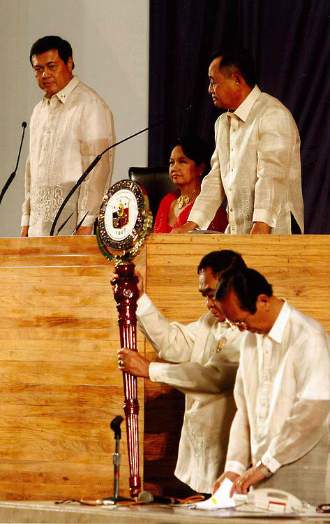 Si Gloria Arroyo na tila isang punong saserdote na pinamumunuan ang isang ritwal ng bansa.