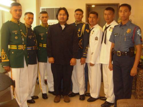 Si Xiao Chua kasama ang mga honor guard mula sa iba't ibang mga sangay ng Sandatahang Lakas at ng pulisya na nagbigay parangal sa Pangulong Cory, kabilang na sina Navy Petty Officer 2 Edgardo Rodriguez, Army Pfc. Antonio Cadiente, Airman 2nd Class Gener Laguindan, at Police Officer 1 Danilo Malab, Jr. Mula sa Koleksyon ng Sinupan ng Aklatang Xiao Chua.