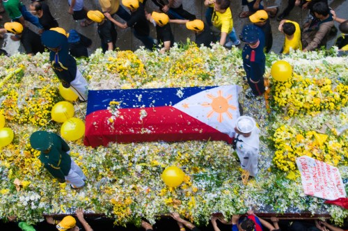 Si Tita Cory na nakabalot ng bandilang Pilipino.