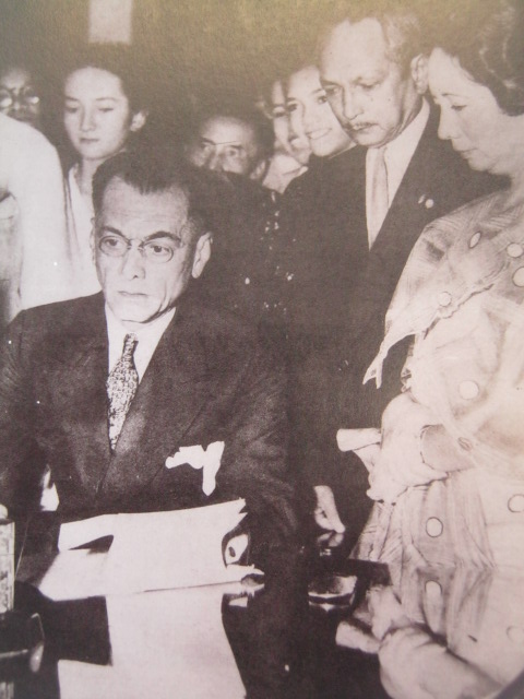 Si Quezon habang nilalagdaan ang pagboto ng mga kababaihan.  Mula sa Manuel Luis Quezon nina Edgardo J. Angara at Sonia P. Ner.