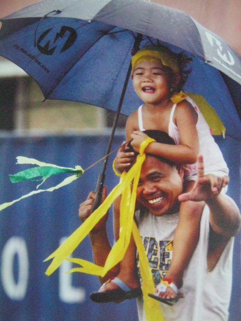 Mga magulang nagbibigay ng isang history lesson sa kanilang mga anak.  Mula sa Cory Magic:  Her People's Stories.